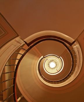 Architectural detail and interior design of spiral staircase, stairwell and daylight from skylight