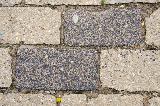 Background of old grunge street pavement made of rectangular bricks.