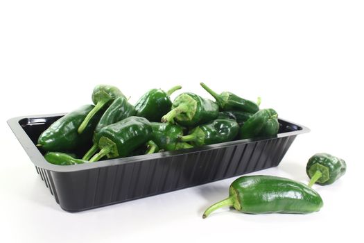 green pimientos in a bowl on light background