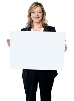 Portrait of a happy young woman holding a blank billboard over white background
