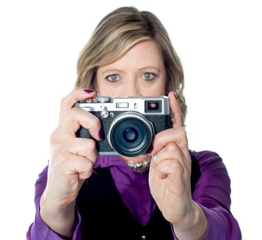 Portrait of a beautiful woman using camera against a white background