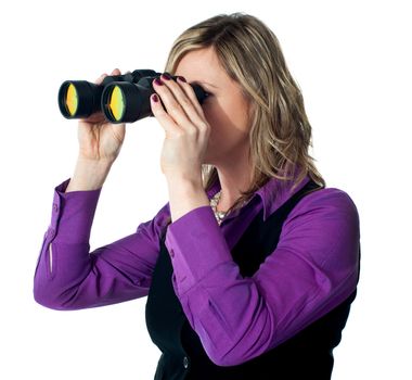 Businesswoman looking through binoculars against a white background