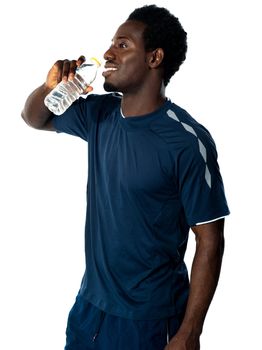 Tired african athlete drinking water against white background