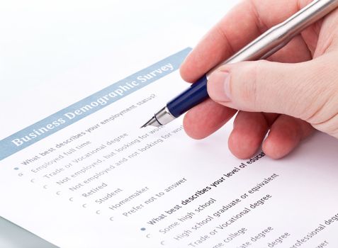 hand with a fountain pen bent over a document