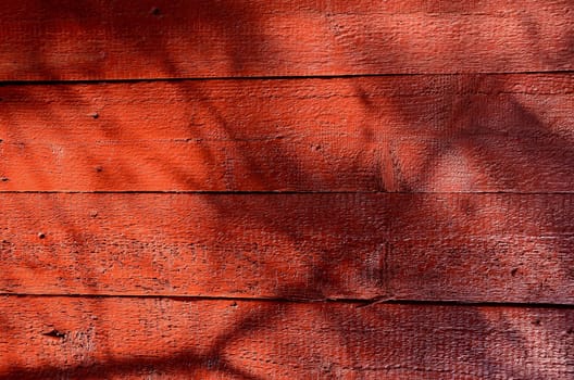 Red-painted wall boards background with shadows.