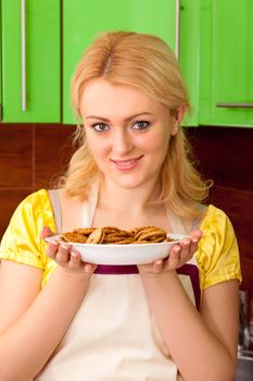 Young housewife cooked meal in kitchen interior