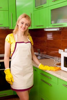 young attractive woman clean the kitchen ( green color )