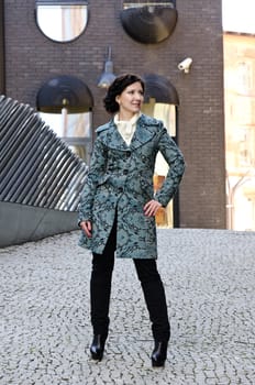 Pretty girl posing outdoors in the coat
