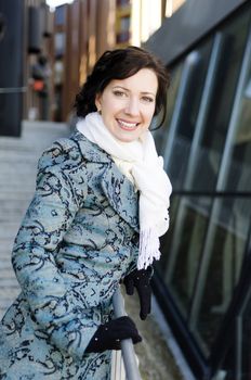 Portrait of a smiling pretty girl with a scarf on the street