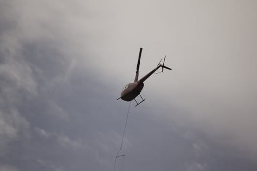 Helicoptor with a water bucket fighting fire
