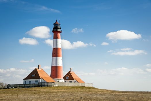 Recording in landscape from the lighthouse westerhever on a sunny day with blue sky and white clouds.