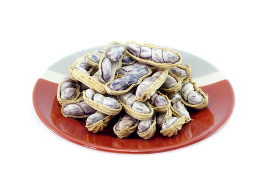 Peanut on red and gray plate isolated on white background.