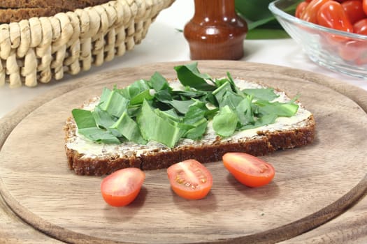 fresh bread with butter and ramson on a light background