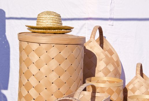 wicker baskets and hats made of wood canes twigs sold at market fair.