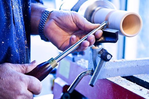 Old worker hands at lathe
