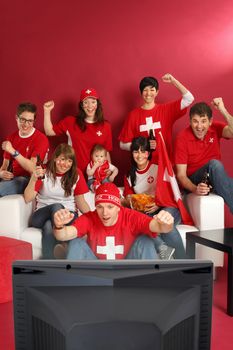 Photo of Swiss sports fans watching television and cheering for their team. Plenty of copyspace.