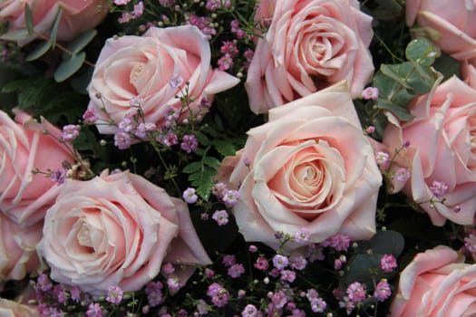 Big pink roses with waterdrops in a floral arrangement