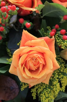 big orange rose in flower arrangement