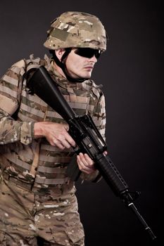 Modern soldier with rifle isolated on a black background