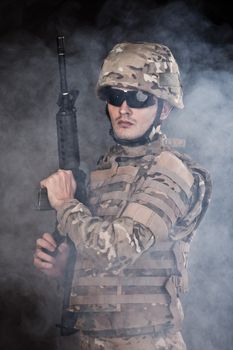 Modern soldier with rifle isolated on a black background