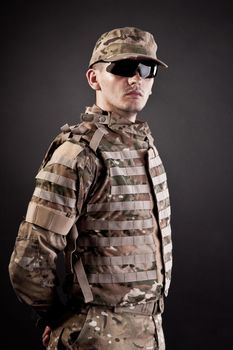 Half length photogaph portrait of adult man in his US Army uniform; copy space on black background