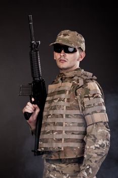 Modern soldier with rifle isolated on a black background