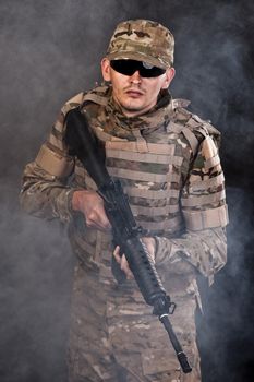 Modern soldier with rifle isolated on a black background