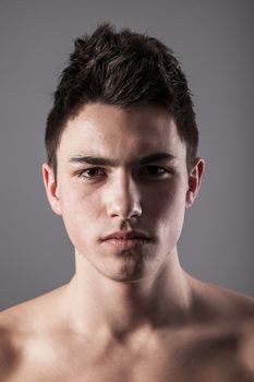 Handsome face of a young man. Isolated on grey background.