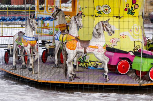 Amusement park carousel entertainment colorful cars and horses.
