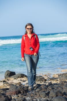 Sports young woman with backpack. In the background of the sea. Vertical view