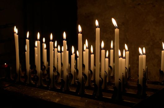 Some church candles against a dark background