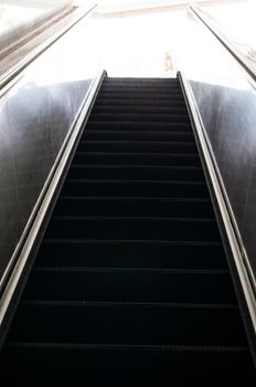 Modern escalator moving up into bright colours