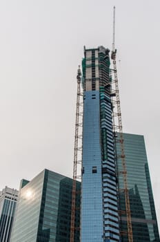 High rise construction site with crane in downtown Singapore
