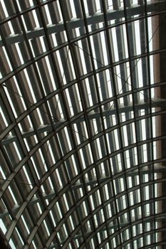 Closeup of a curved reinforced steel roof with glass panes