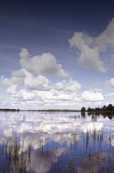Background of cloudy sky reflection on lake water. Romantic natural beautiful view in summer sunny day.