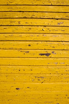 ancient retro yellow painted wooden wall with peeling paint background.