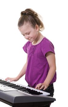 young girl playing music on a keyboard