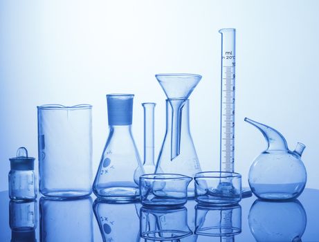 Research Lab assorted Glassware Equipment on blue background