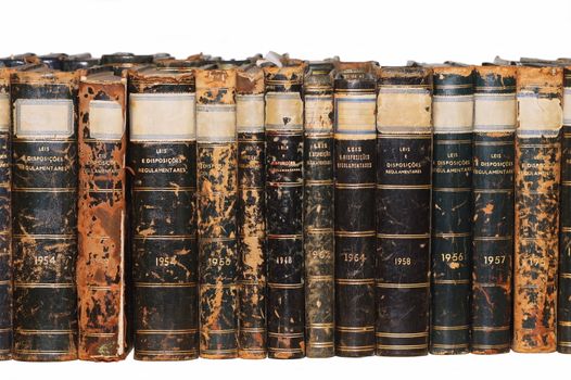 Row of old books isolated on white background. Many of the books show lots of wear and damage from aging. The text in the book cover isn't a trademark.