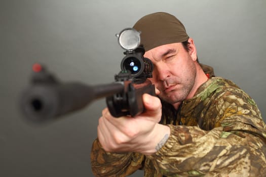 the man in a camouflage aims from a rifle with a riflescope. double 3