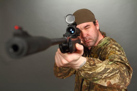 the man in a camouflage aims from a rifle with a riflescope. double 4