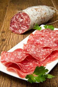 Salami sliced on wood background