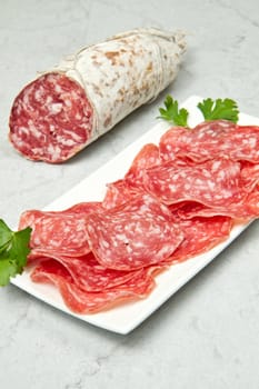 Salami sliced on marble table