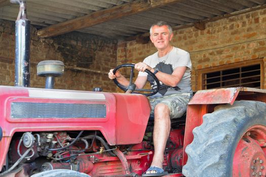 Horizontal portrait of a happy farm worker tractor driver operator about to move off