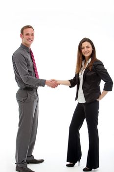 Two stylish business executives stand shaking hands at the conclusion of a successful business deal