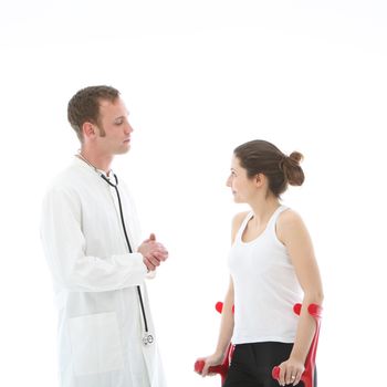 Disabled young female patient on crutches standing having a conversation with her doctor concerning her recovery