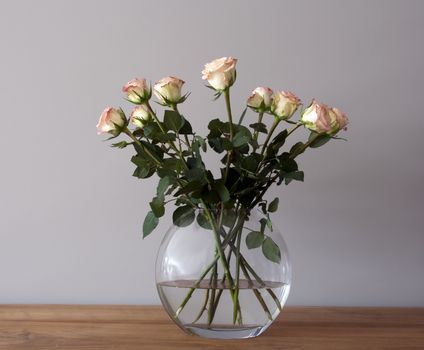 bouquest of roses in a vase on wooden table