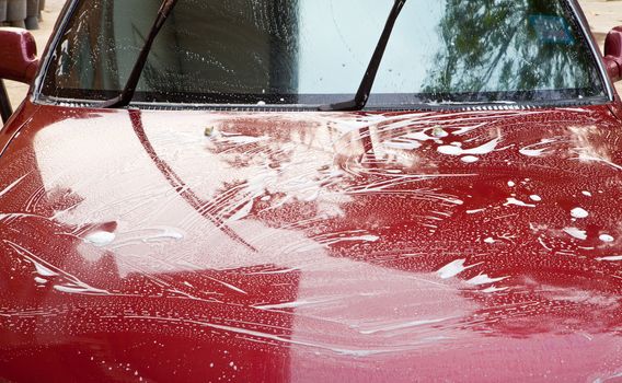 photo dirty car being washed outside with soap