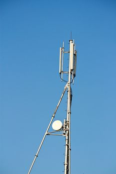 Modern cell and antenna with flat parabola on blue sky