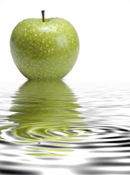 Fresh smith apple reflected on water on a white background.